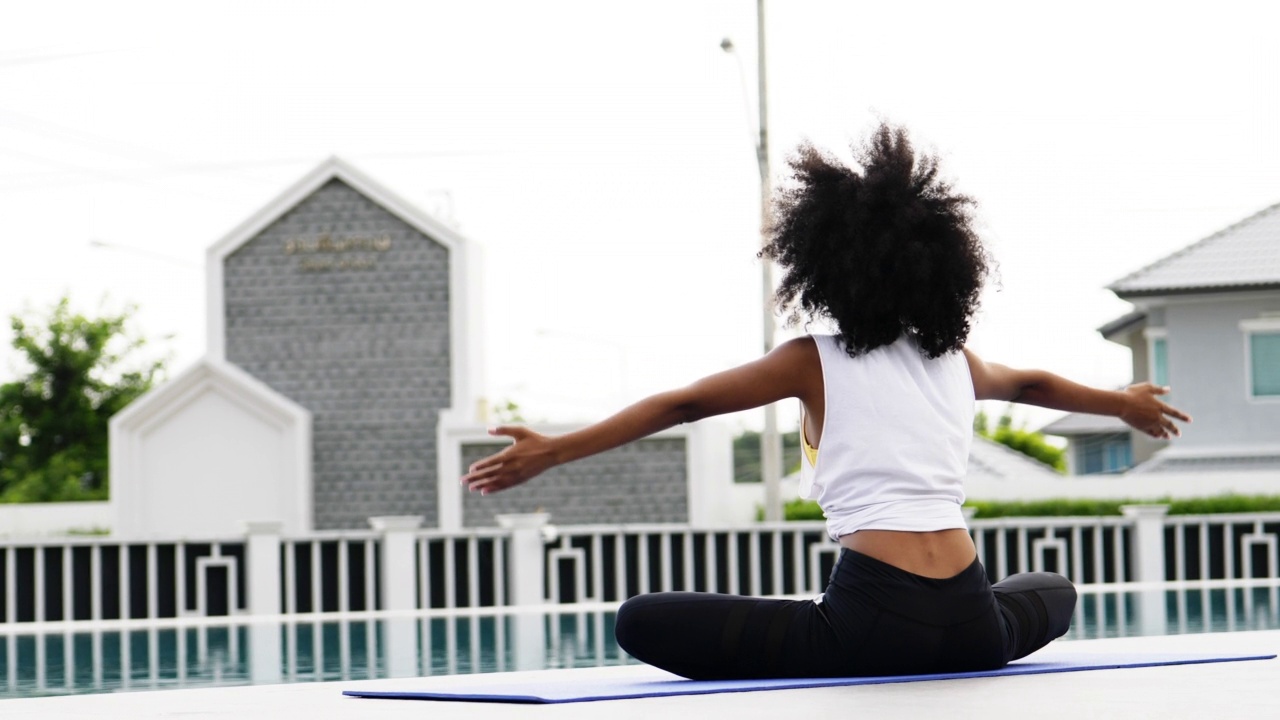 瑜伽是非洲妇女在游泳池里做的。视频素材