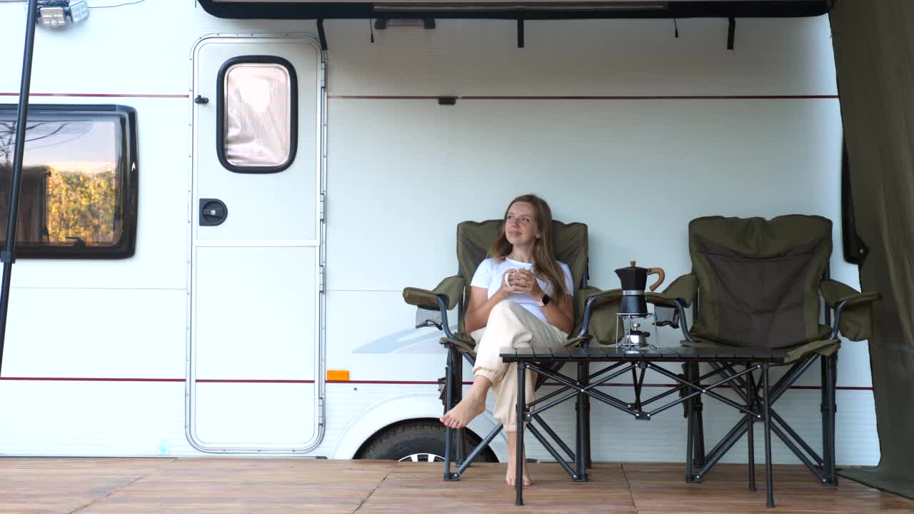 一个年轻漂亮的女人在露营车外喝咖啡视频下载
