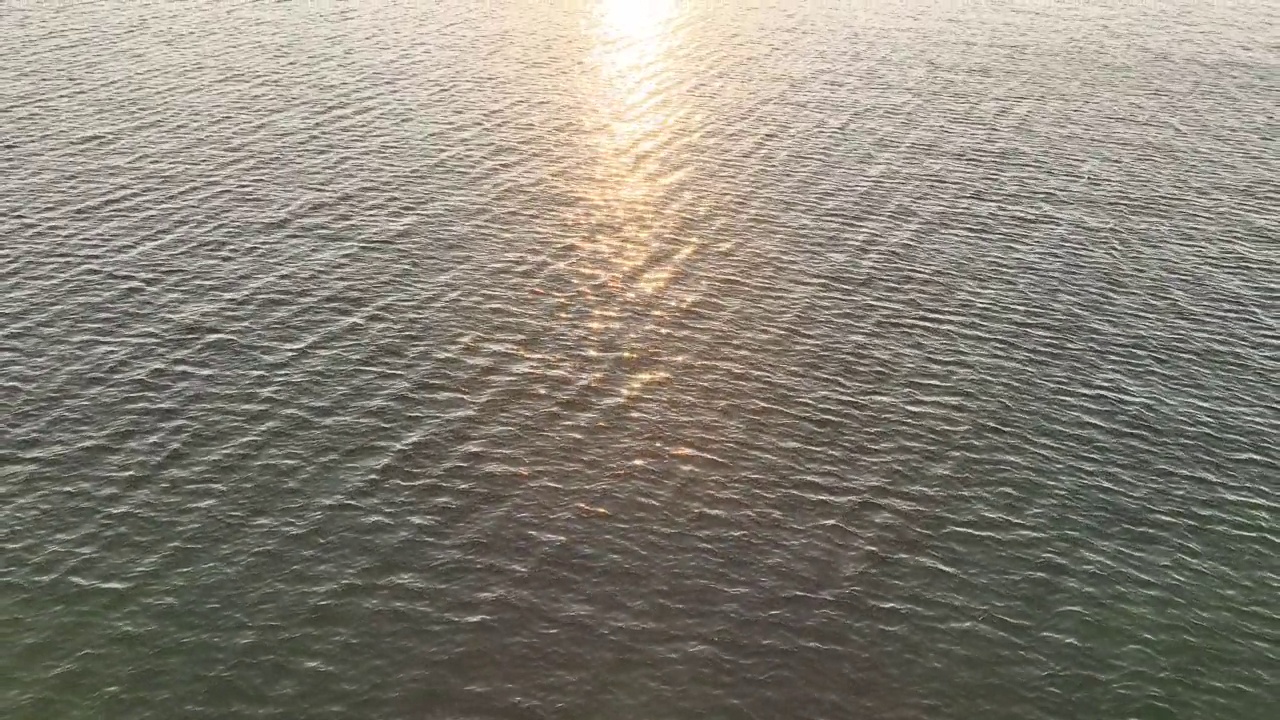阳光路径淡蓝色的水与金色阳光散景圈视频素材