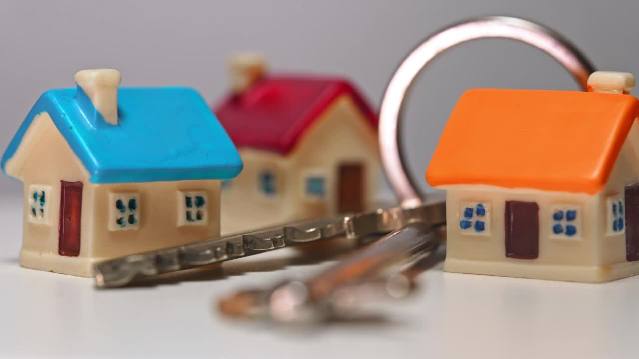 三个玩具房子和钥匙。房地产的概念。视频素材