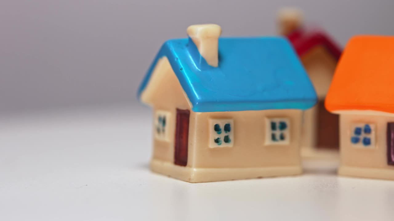桌子上有三个玩具房子。房地产的概念。视频素材