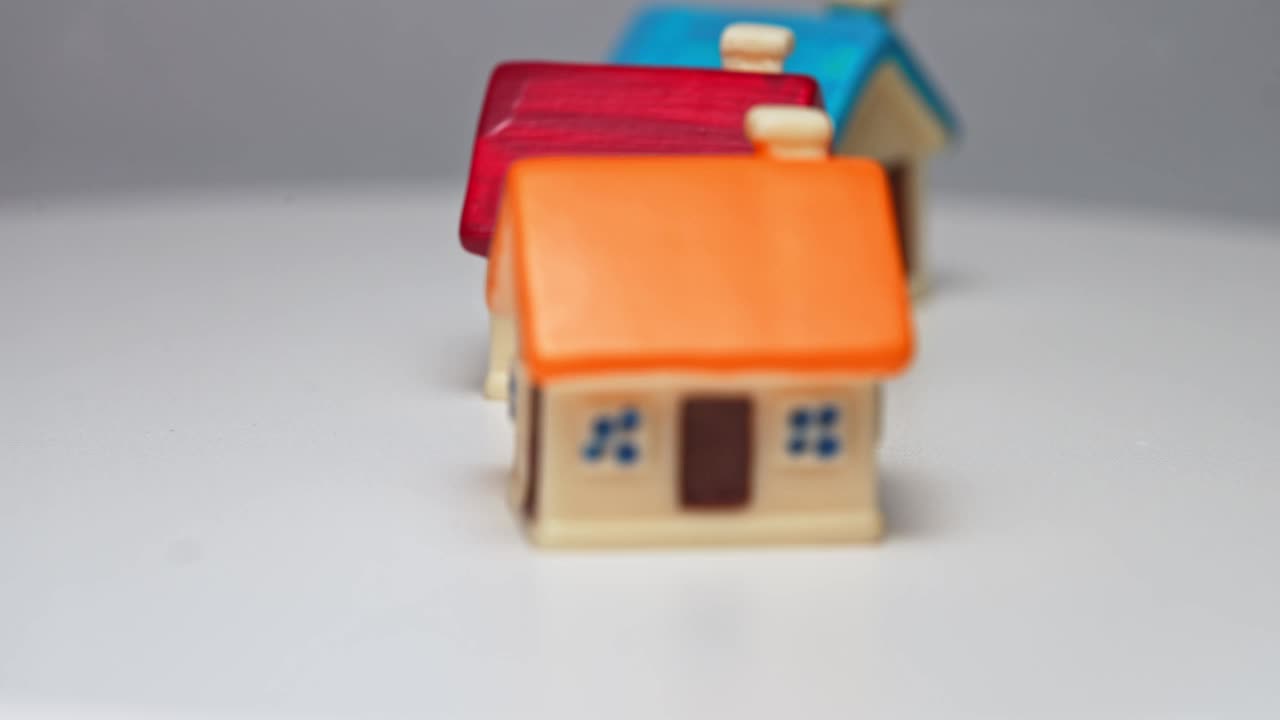 桌子上有三个玩具房子。房地产的概念。视频素材