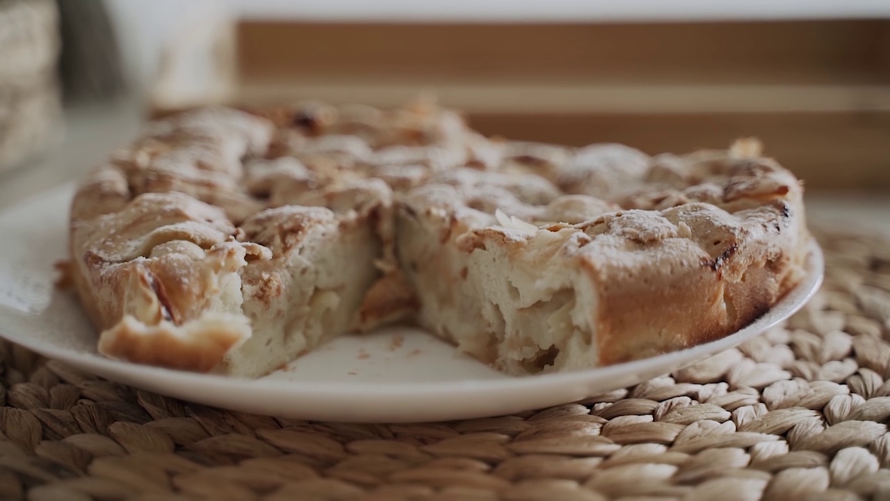 夏洛特苹果派的特写，它躺在餐巾上的白色盘子上视频素材