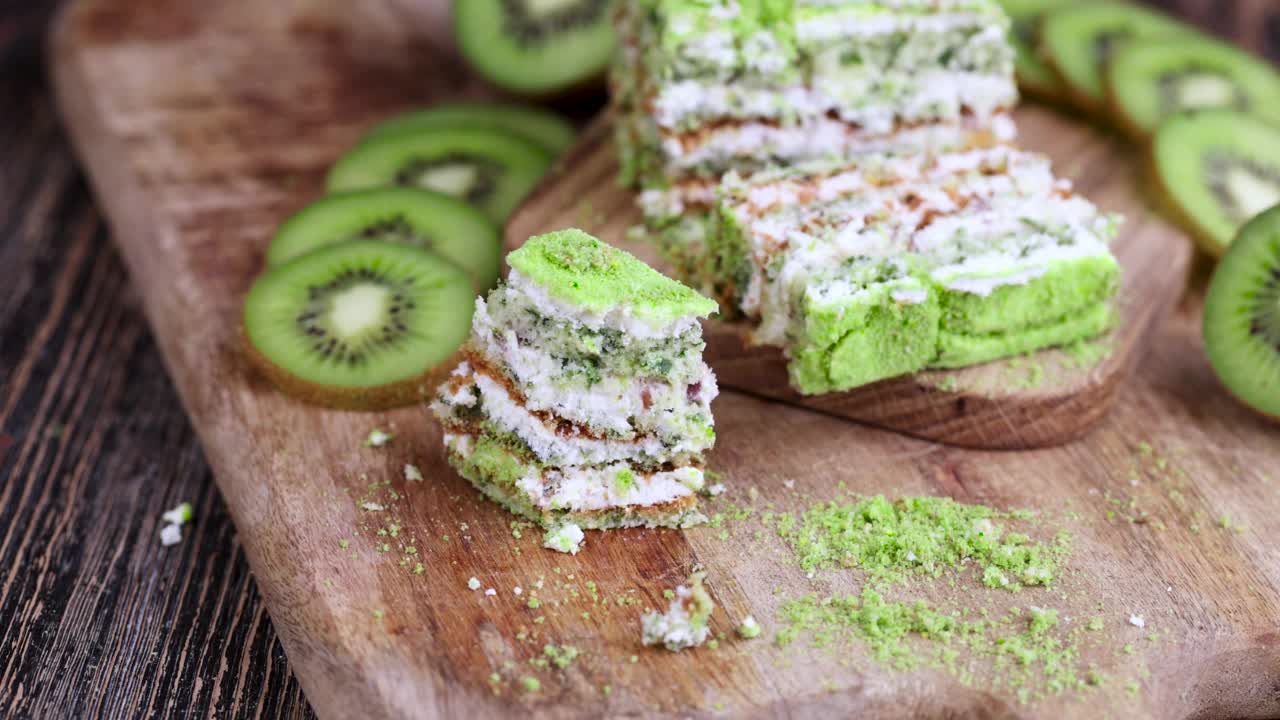 用叉子拿一块水果口味的绿色蛋糕和绿色猕猴桃切片视频素材