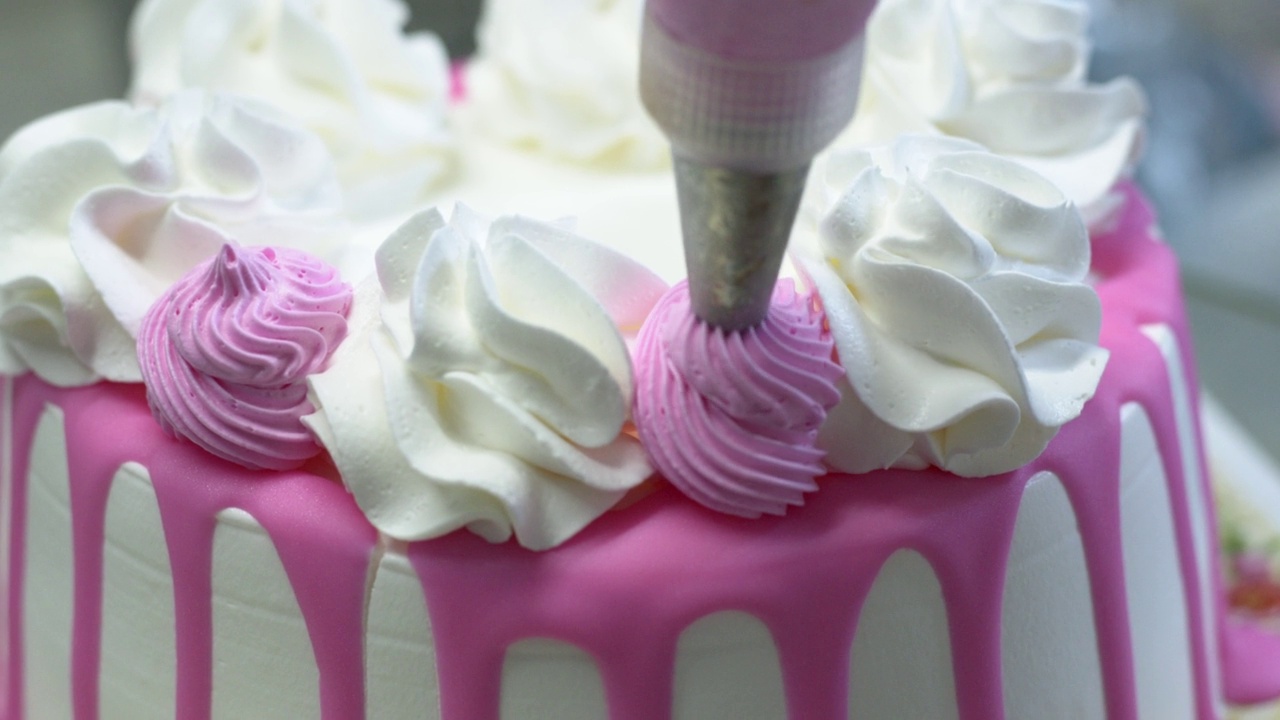 糕点师用鲜奶油装饰蛋糕。视频下载