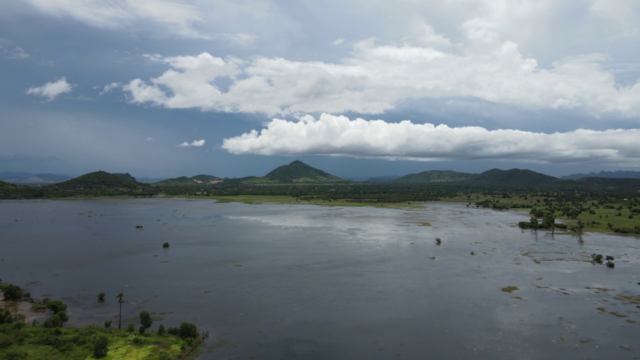 无人机拍摄的一个巨大的湖泊被群山环绕的云视频素材