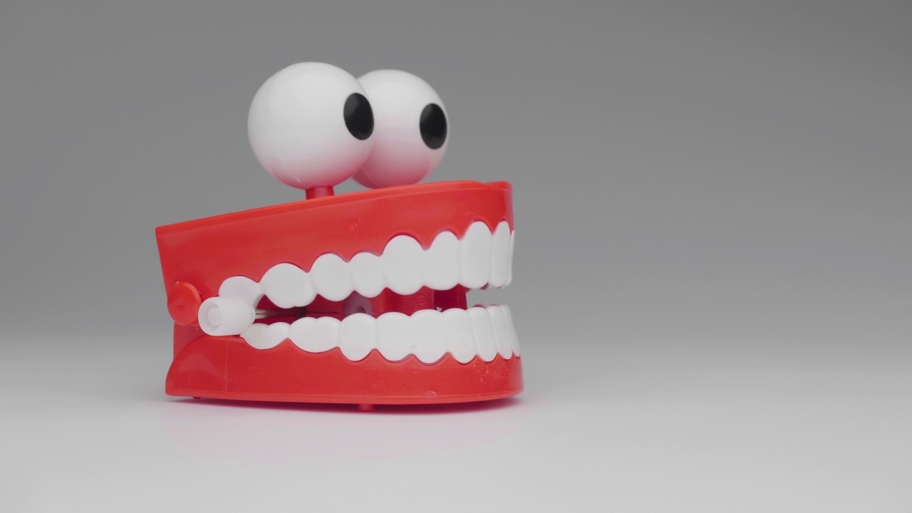 Сhattering牙齿玩具移动在白色背景。视频素材