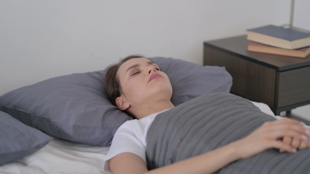 女人在床上睡觉时感到不舒服视频素材