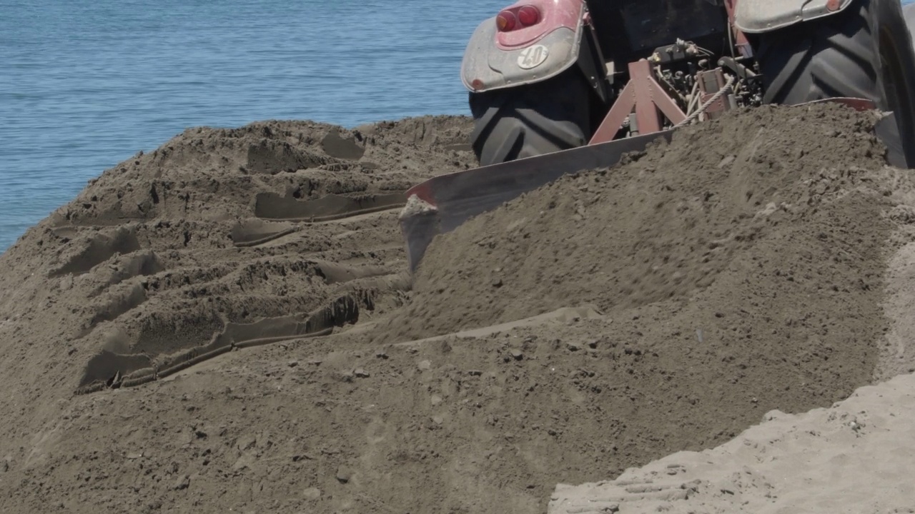 在海滩上铲沙的拖拉机视频素材