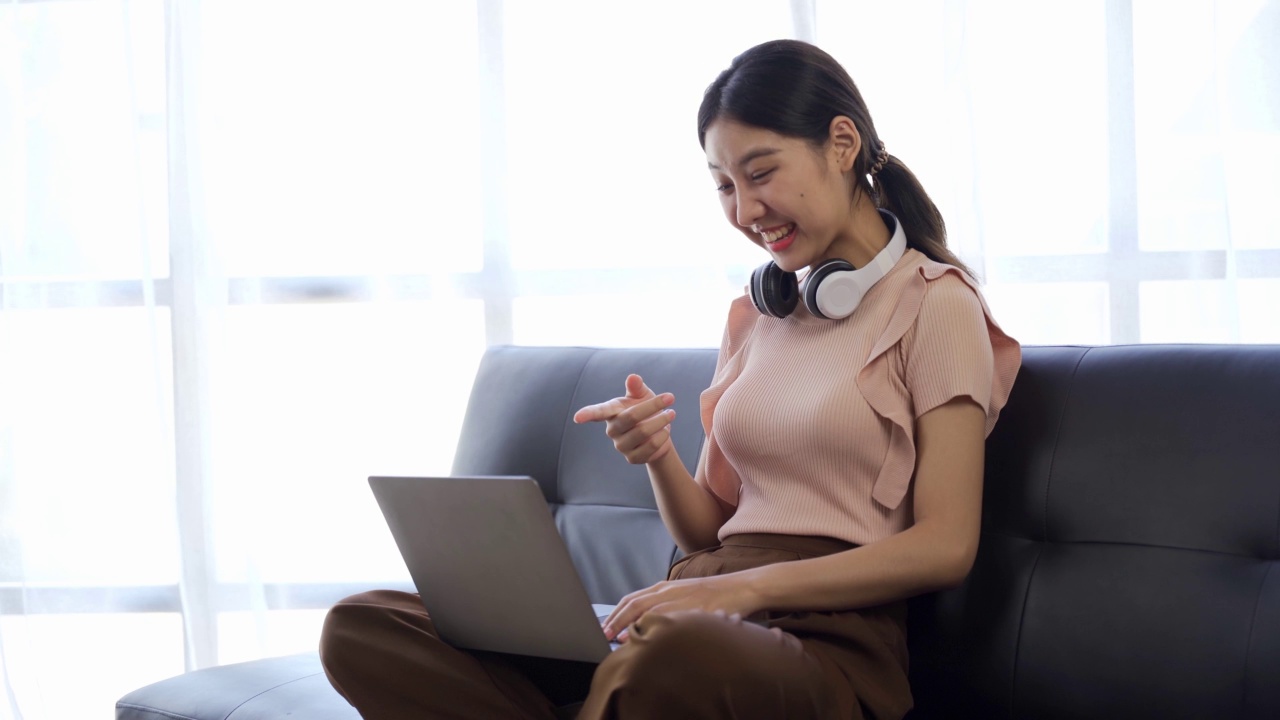 坐在沙发上使用笔记本电脑的亚洲女性视频素材