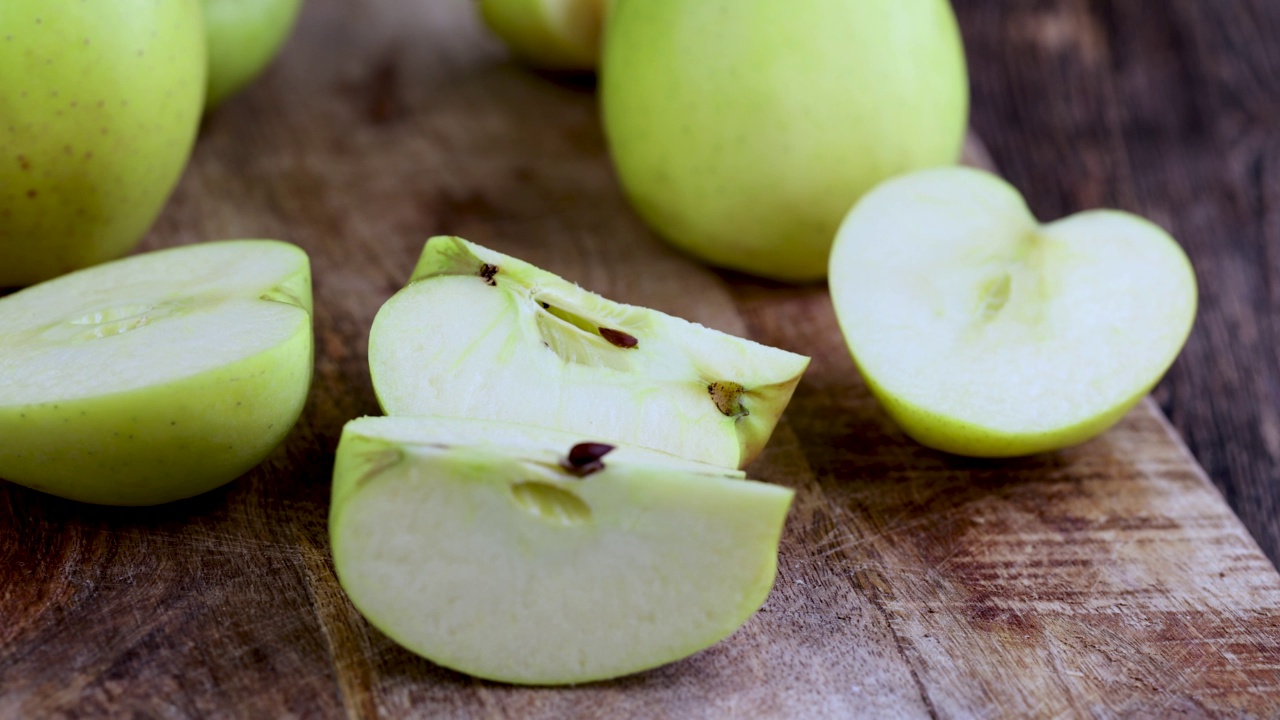 一个带皮的青苹果在烹饪时在木板上摇摆视频素材