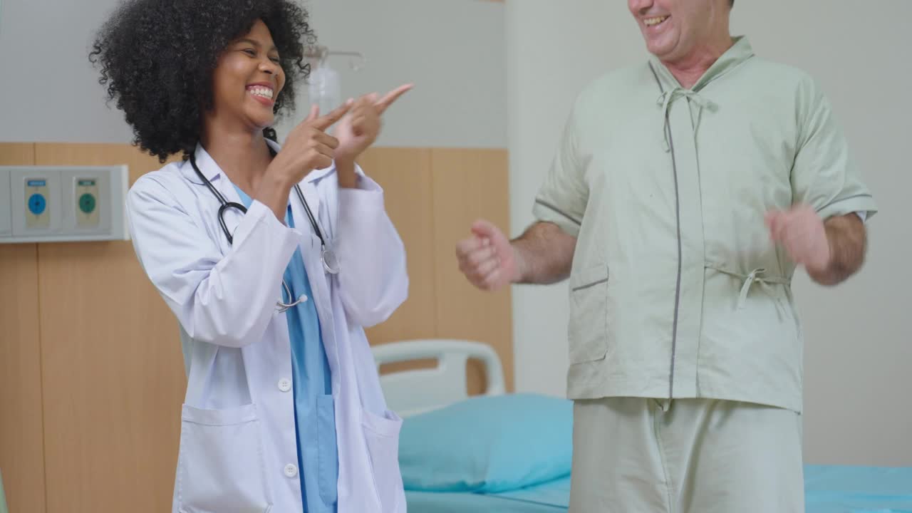 快乐的非洲裔美国黑人女医生与老年病人在医院跳舞。老年人保健理念视频素材