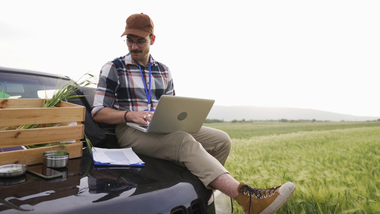 在田间使用笔记本电脑的年轻农民视频素材