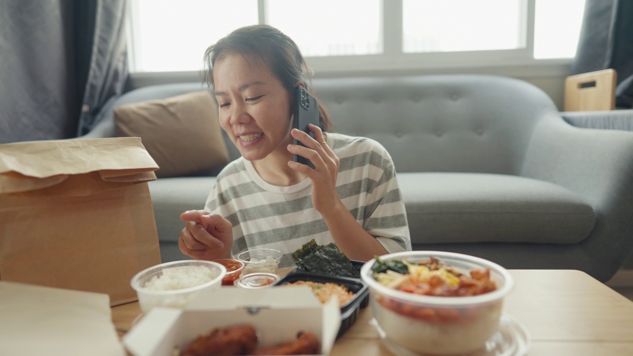 亚洲年轻的成年母亲在家里和女儿一起吃午餐时，会点外卖炸鸡视频下载