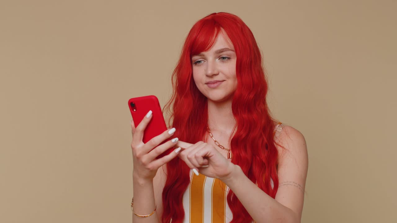 红发女孩利用手机打字发帖子，上网发短信，浏览社交网络成瘾视频素材