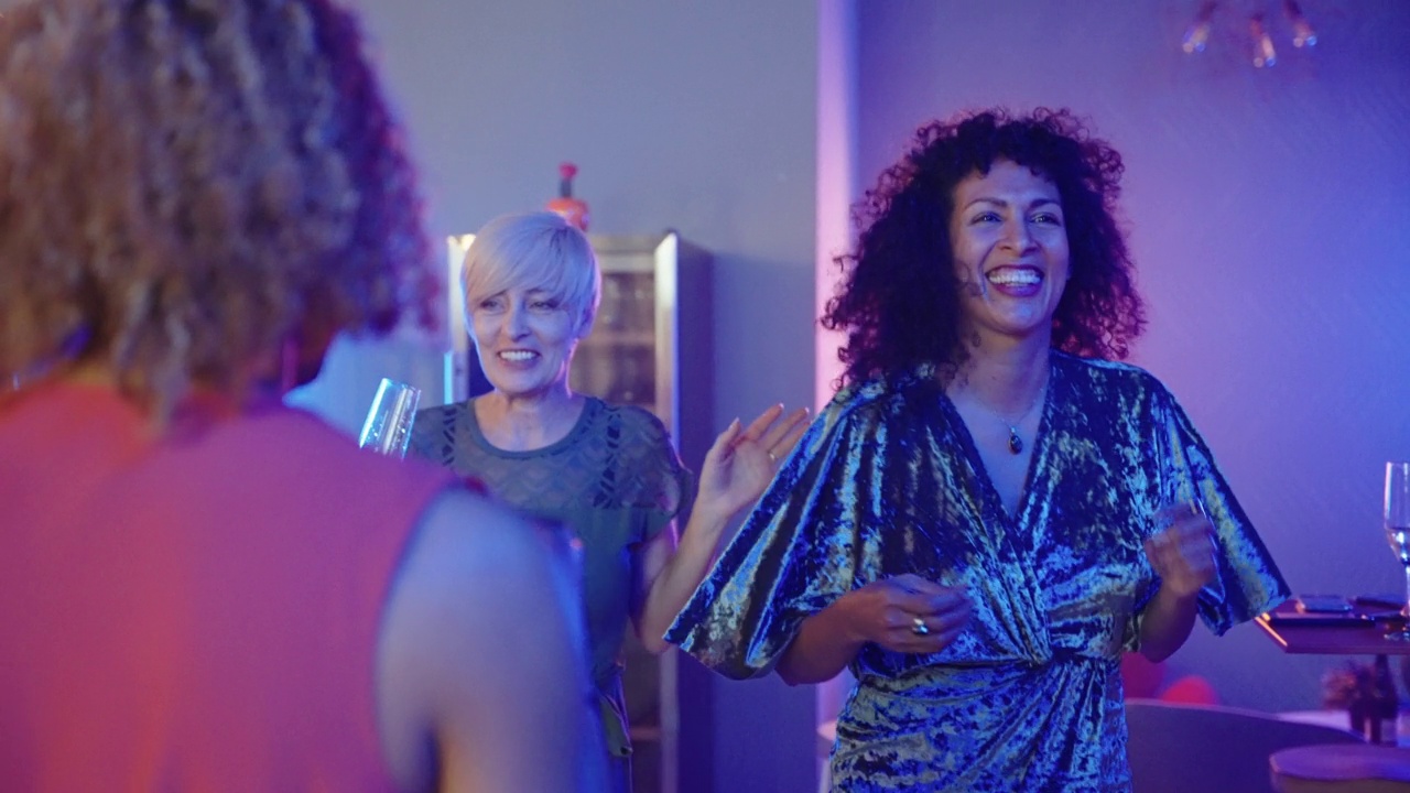 一名微笑的西班牙女子在派对上与她的同事跳舞视频素材
