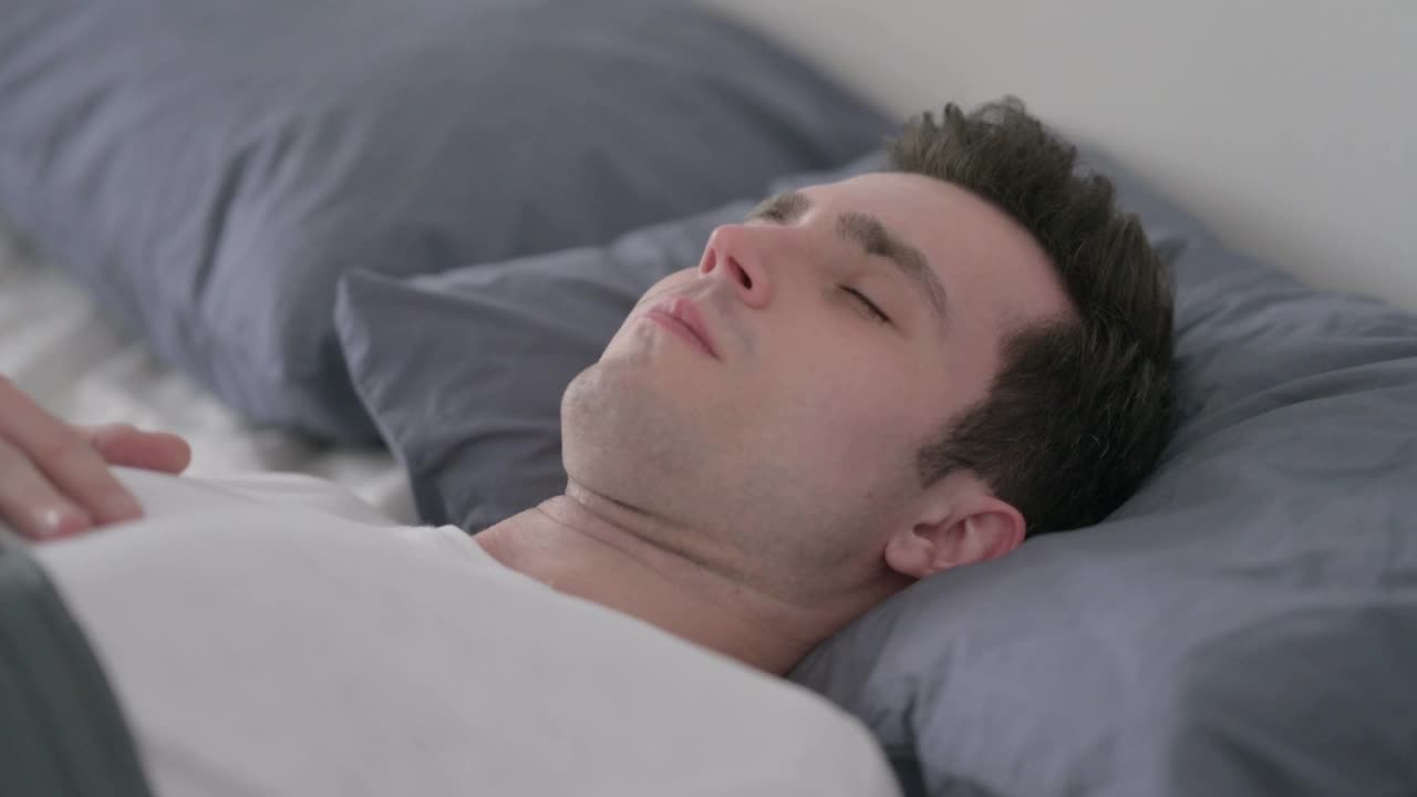 男子在床上醒着咳嗽，特写视频素材