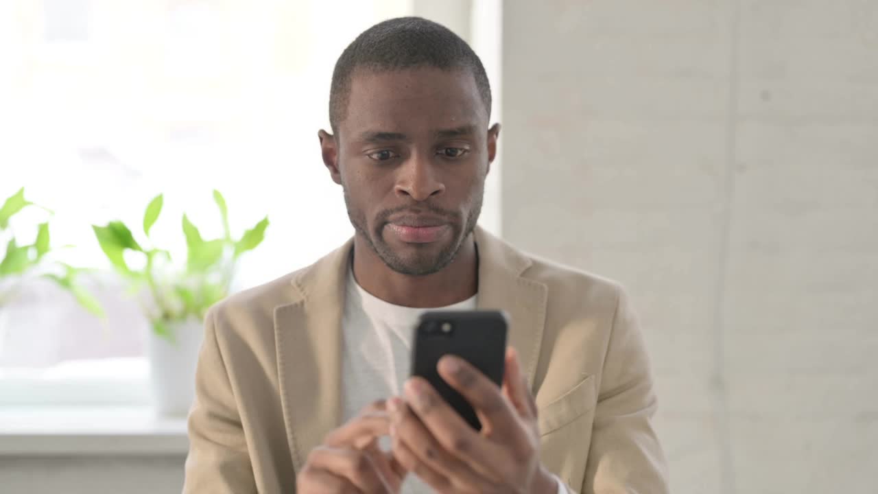 非洲男子在智能手机上说话的肖像视频素材