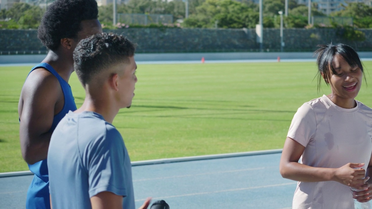 年轻的田径运动员在阳光灿烂的跑道上交谈视频素材