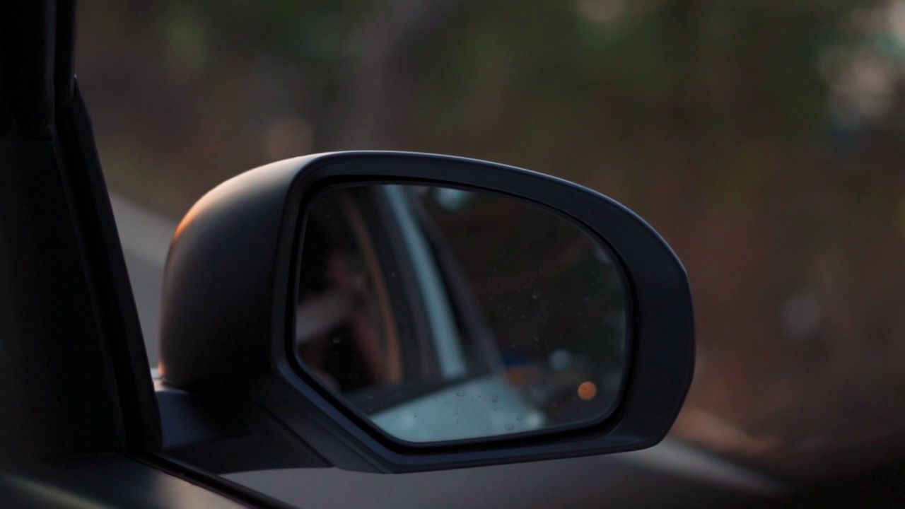 手持特写镜头的汽车的侧镜在高速公路上在印度。白天在路上行驶的汽车。交通工具是汽车背景。自驾游概念车。视频素材