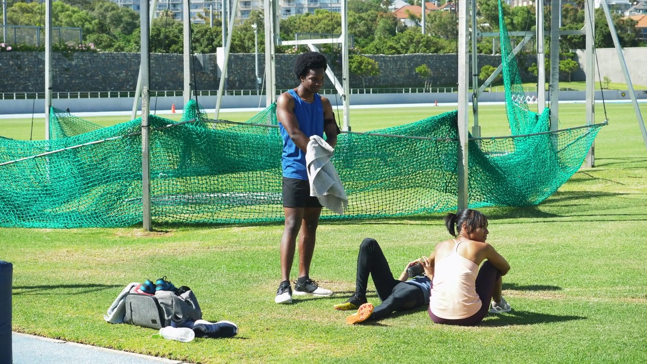 年轻的田径运动员在阳光明媚的草地上休息视频素材