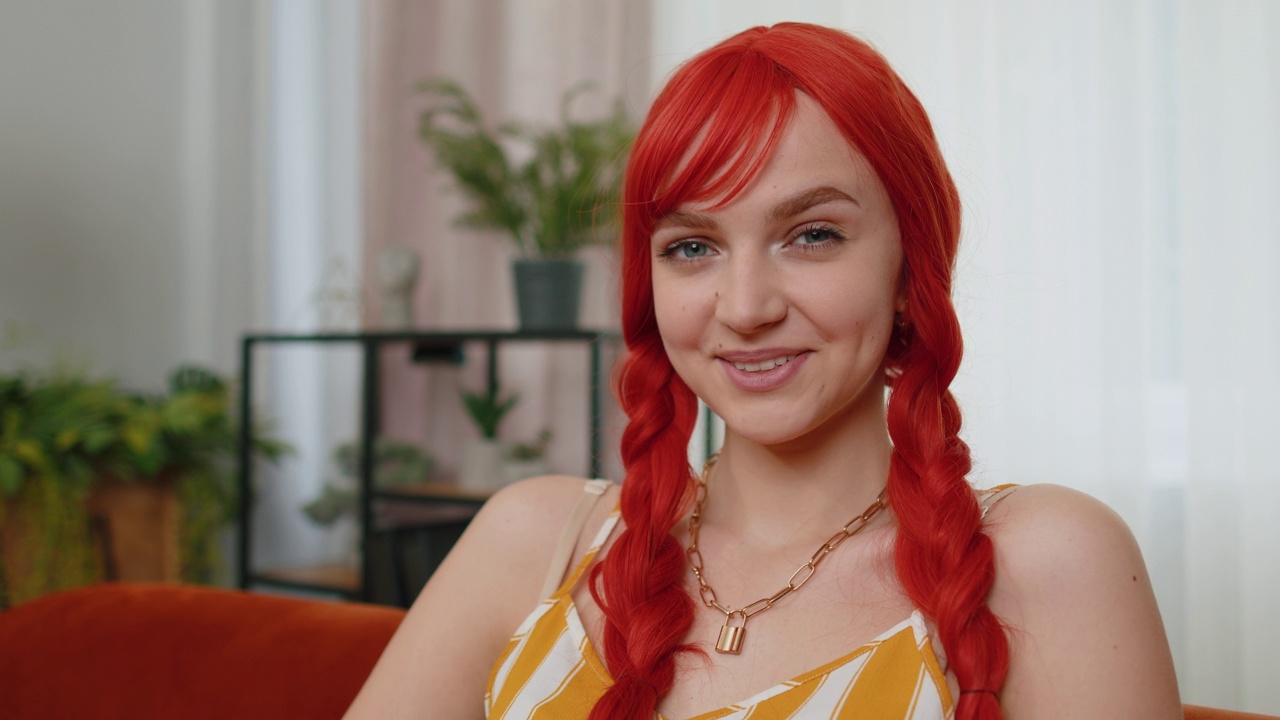 特写快乐美丽的少女红发姜女人微笑看着相机在家里的沙发上视频素材