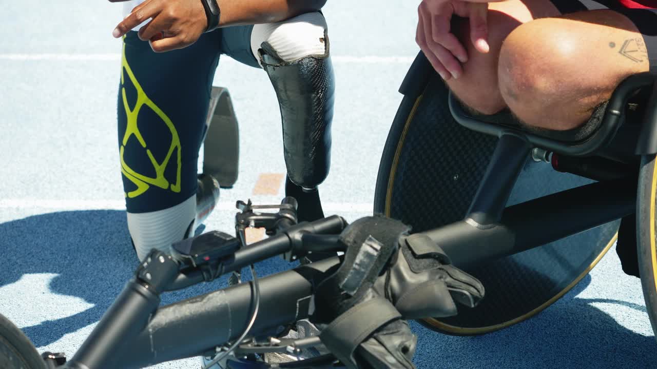 截肢者和轮椅运动员在阳光明媚的跑道上使用智能手机视频素材