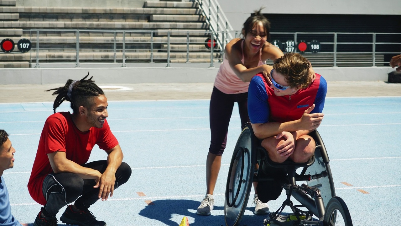 快乐的轮椅运动员和队友在阳光灿烂的跑道上视频素材