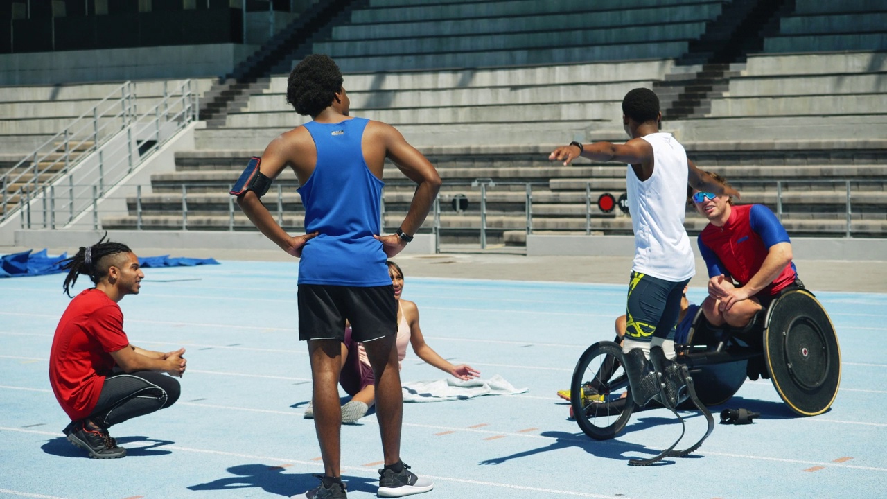 年轻的截肢田径运动员在跑道上与朋友交谈视频素材