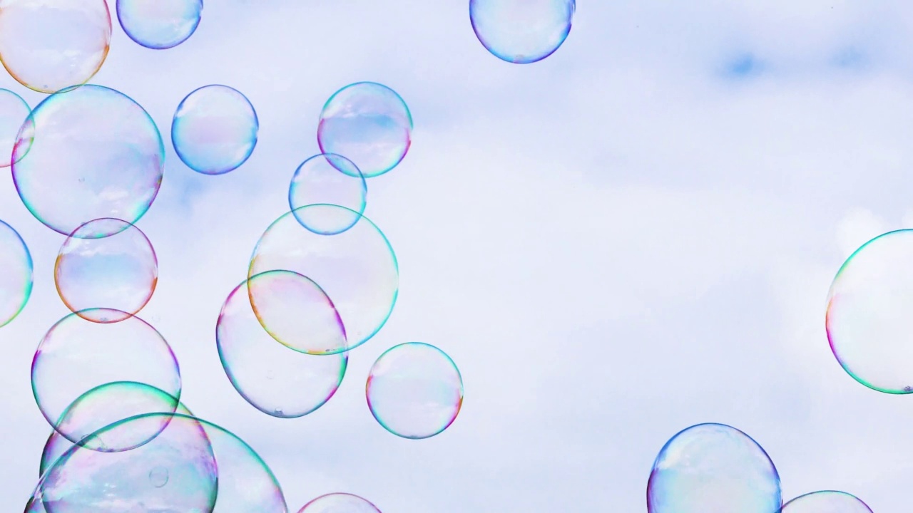 大大小小的、五颜六色的泡泡在蓝天上飞舞。创建一个节日。视频下载