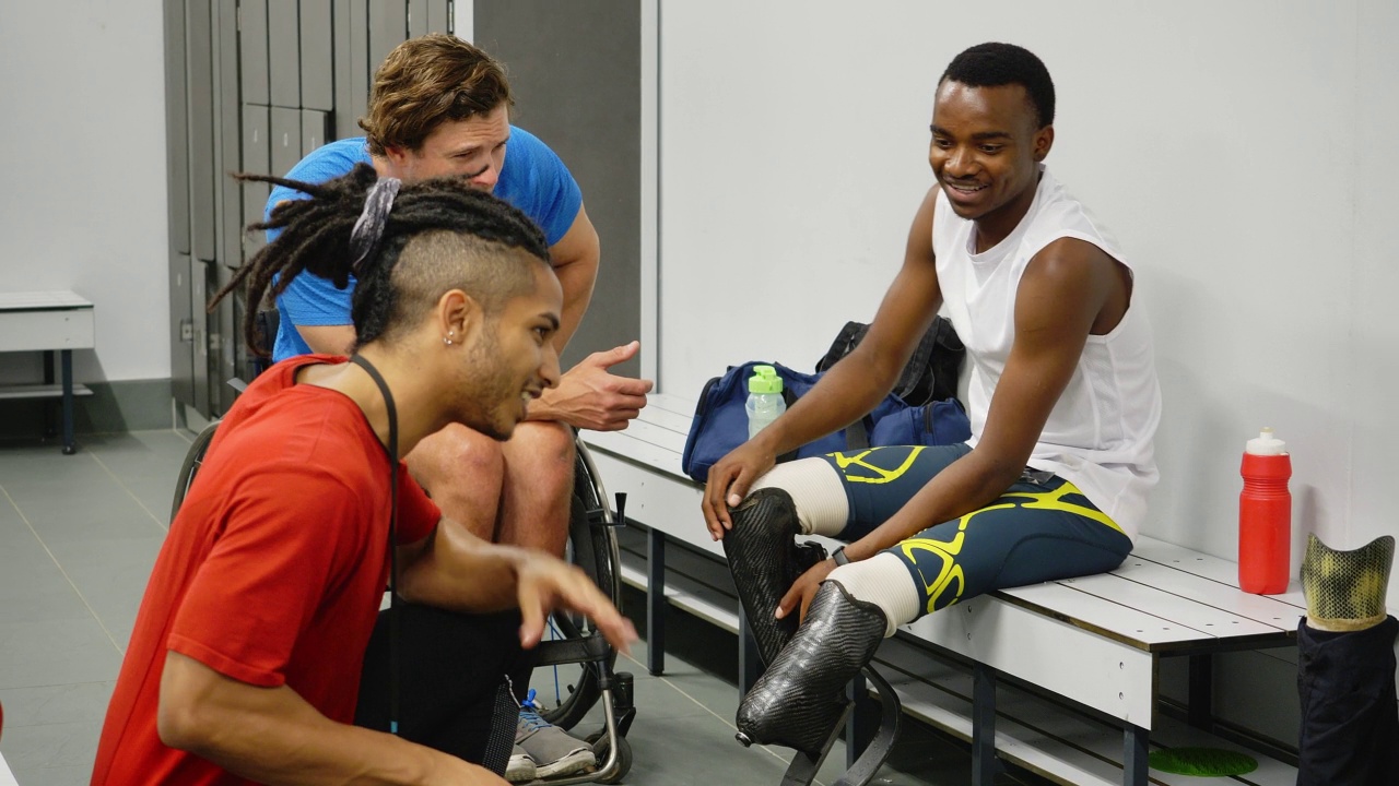 截肢运动员和轮椅运动员在更衣室与教练交谈视频素材