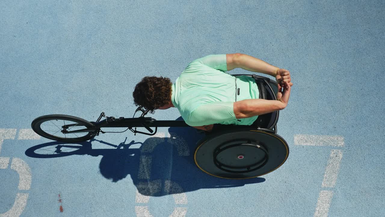 男性轮椅运动员在阳光明媚的跑道上伸展视频素材