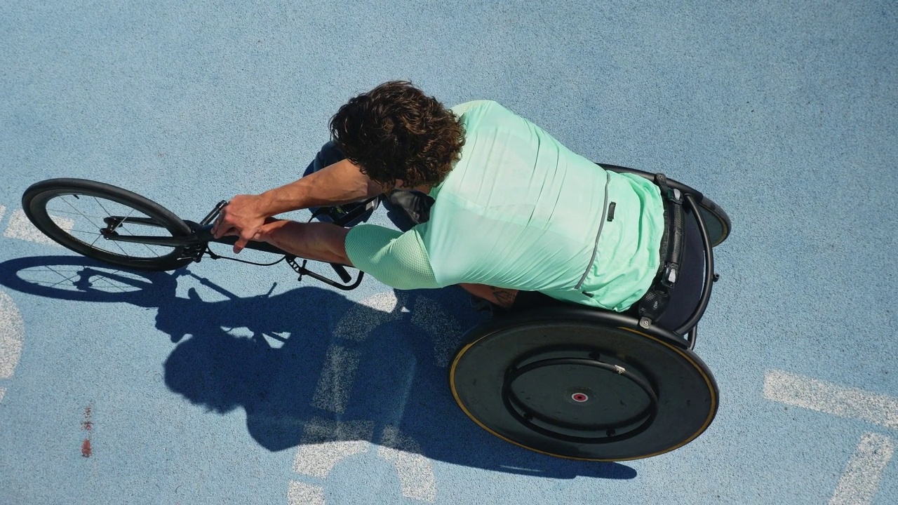 男性轮椅运动员在阳光明媚的跑道上伸展手臂视频素材