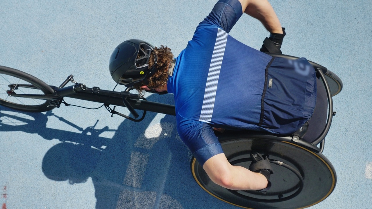 在阳光明媚的蓝色跑道上戴头盔的男性轮椅运动员视频素材