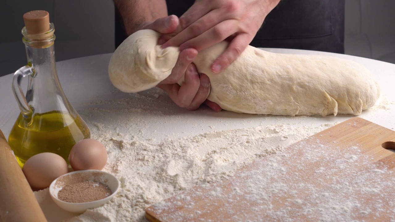 专业的面包师用大块生面团制作面团球。面包师在准备做面包的面团视频素材