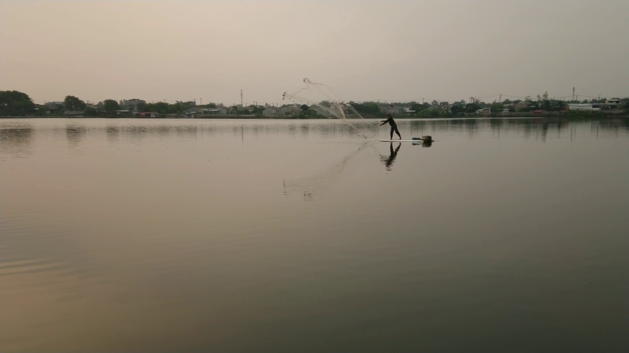 一个渔夫正在湖中撒网视频素材