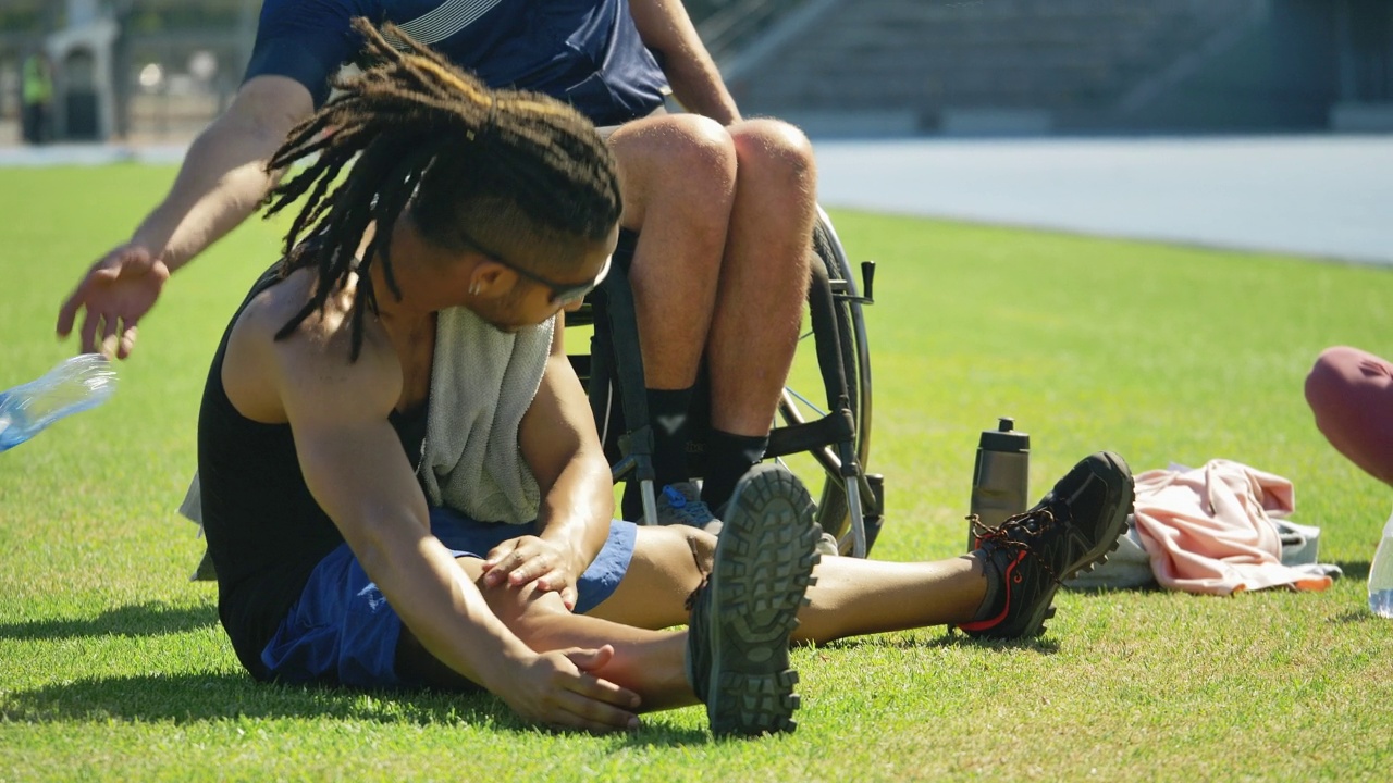 田径运动员在运动场的草地上伸展身体视频素材