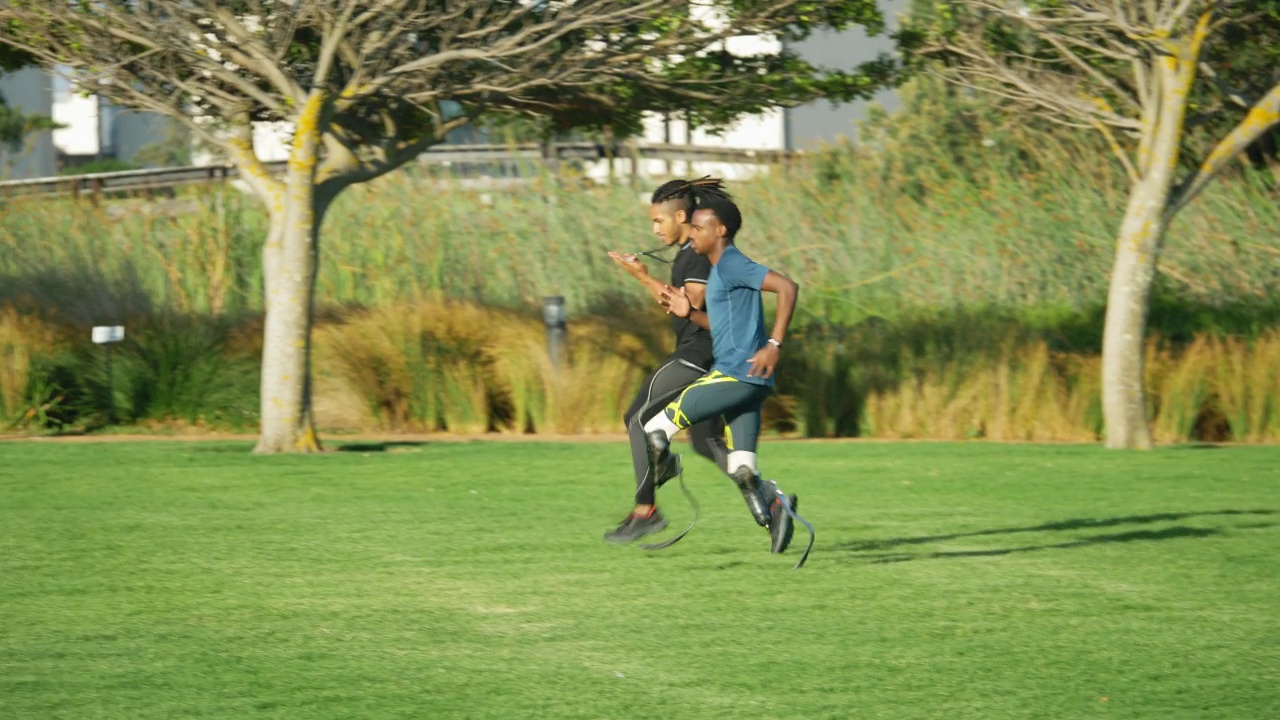 男性教练和截肢运动员在阳光明媚的夏日公园慢跑视频素材