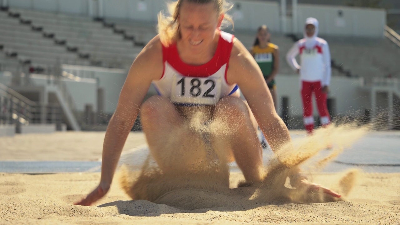 女子田径运动员在沙滩上跳远视频下载