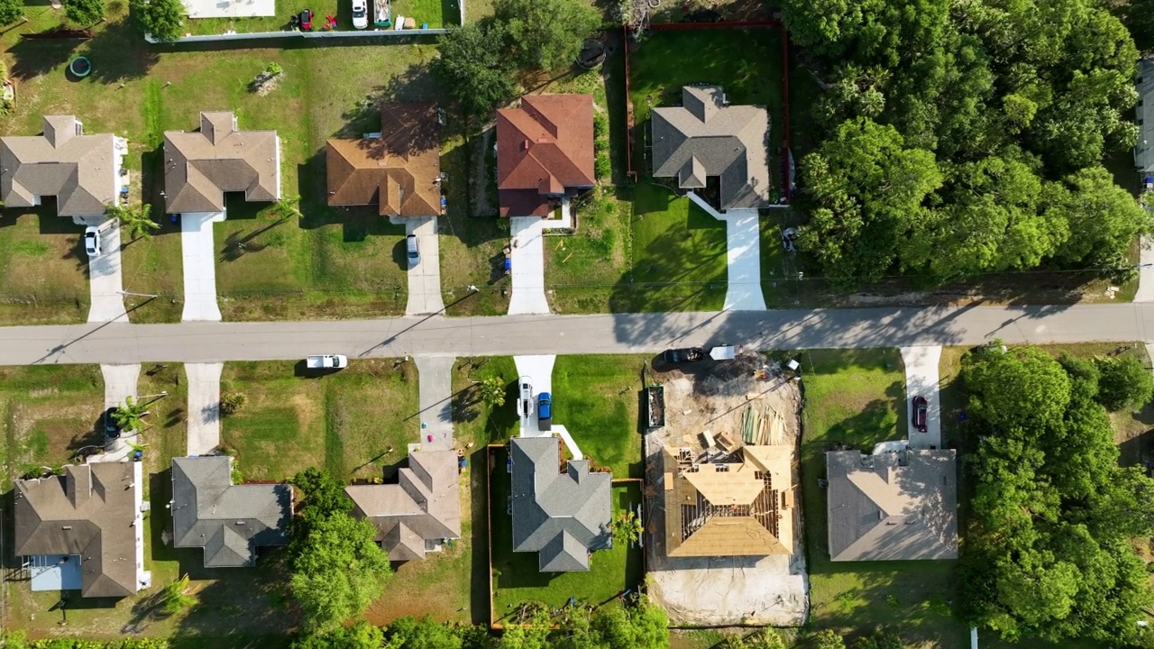 鸟瞰佛罗里达州宁静的住宅区，绿油油的棕榈树之间的私人住宅视频素材