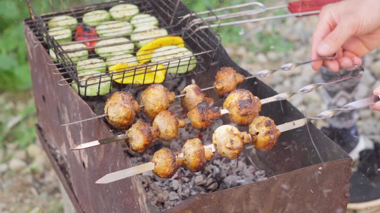 蔬菜蘑菇串是在烤架上准备的。美味多汁的烤蔬菜是大自然中夏日烹饪的最美味的健康食品。香菇在灯下炸。视频素材