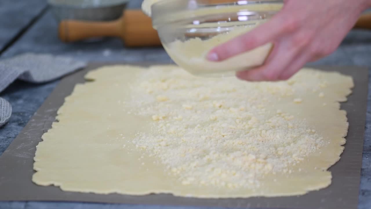 女性手把面团擀成卷，制作面包的烘焙过程。视频下载
