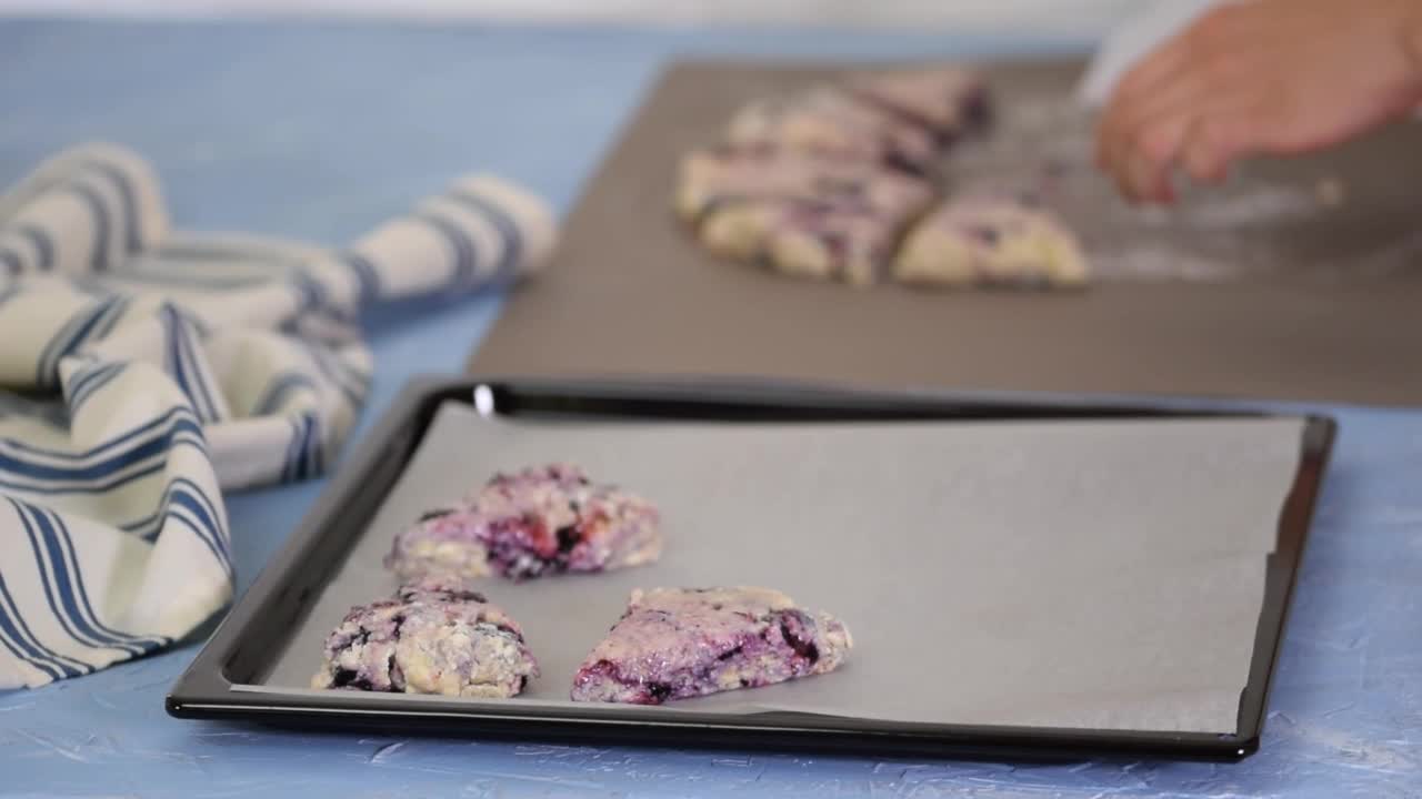 家庭主妇在厨房用蓝莓做英式松饼。视频下载