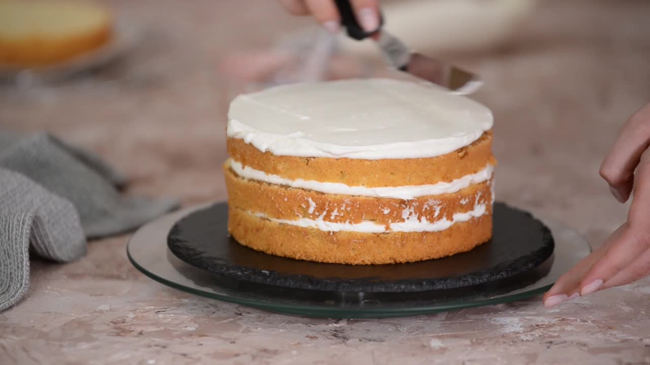 女人的手会用奶油做成分层的蛋糕。视频下载