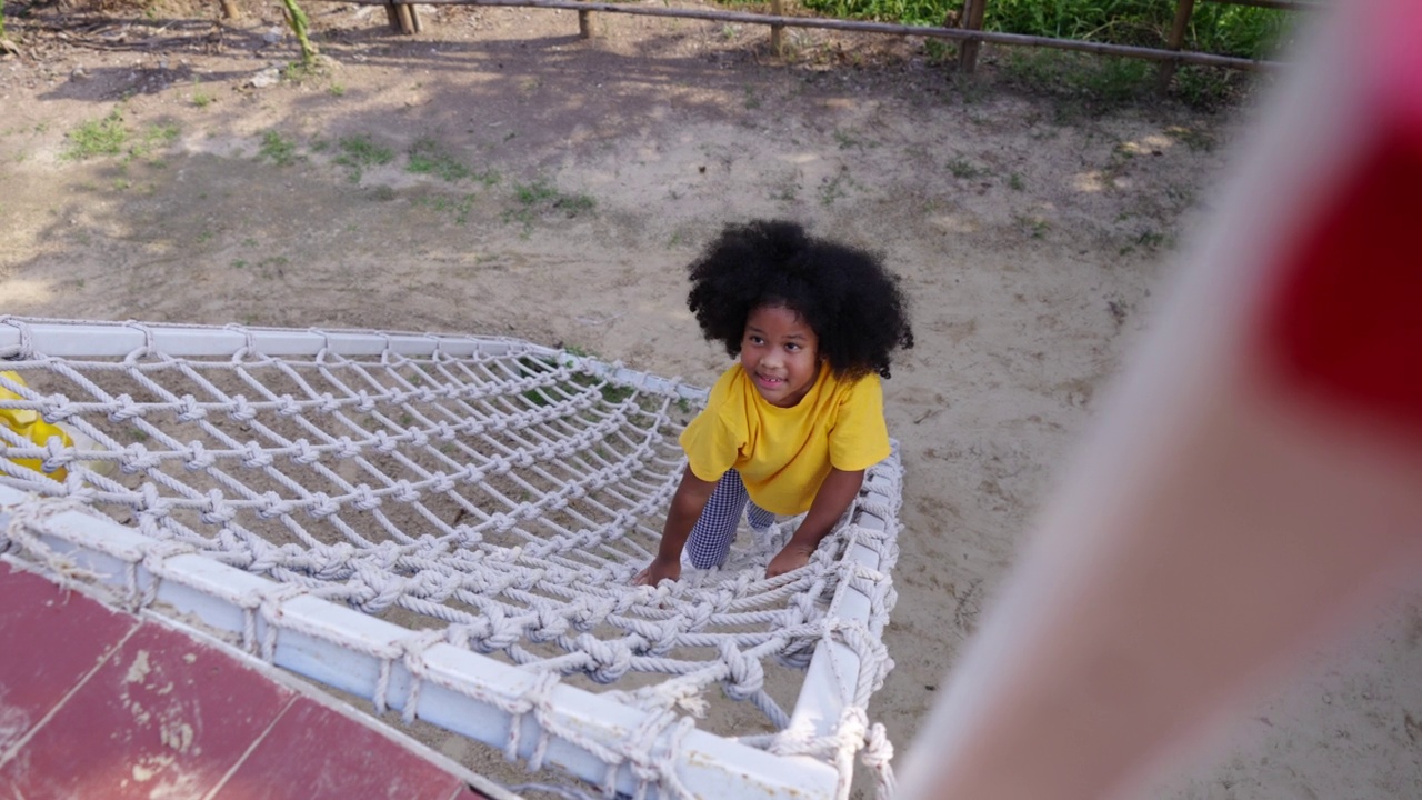 4、非洲小女孩在公园户外操场攀绳网视频下载