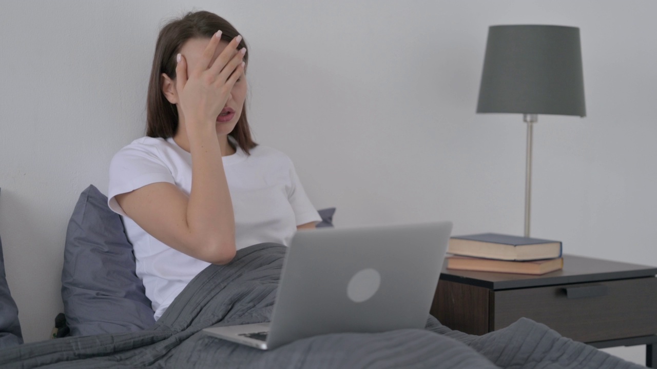 女人对在床上丢失笔记本电脑的反应视频素材