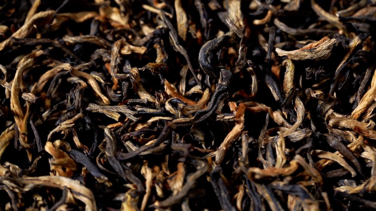 干燥的红茶叶闭合。宏。散叶的黑色大吉岭红茶背景视频素材