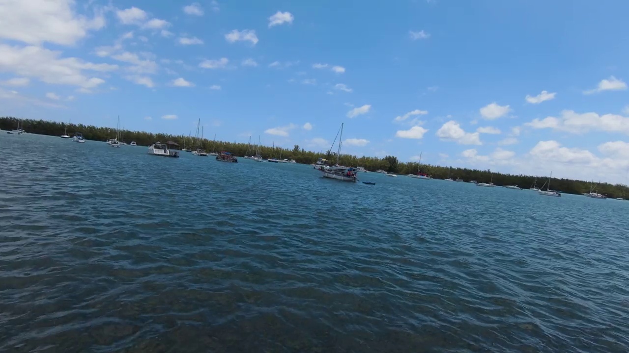 无人机在码头的帆船上空飞行，背景是废弃的迈阿密海军体育场。视频素材