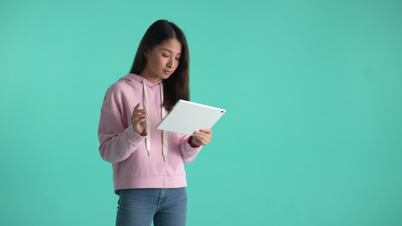 亚洲女孩使用平板电脑隔离的背景视频下载