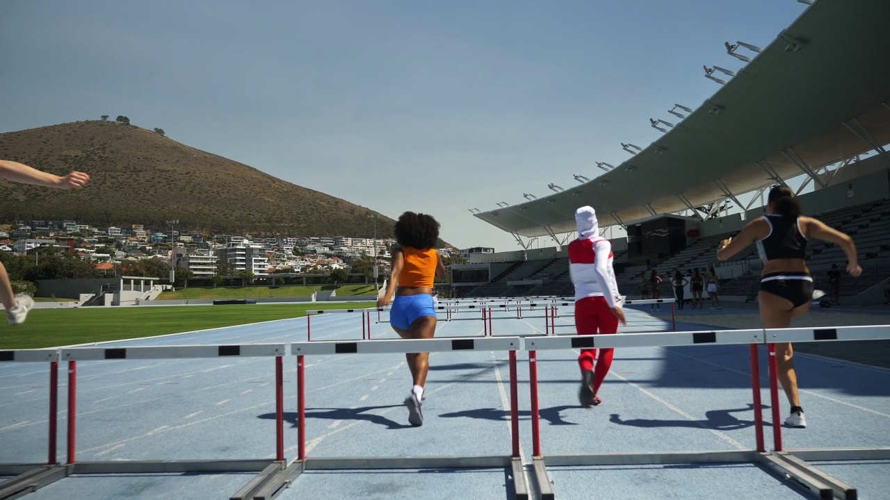 女性田径运动员在阳光明媚的跑道上跨栏视频下载